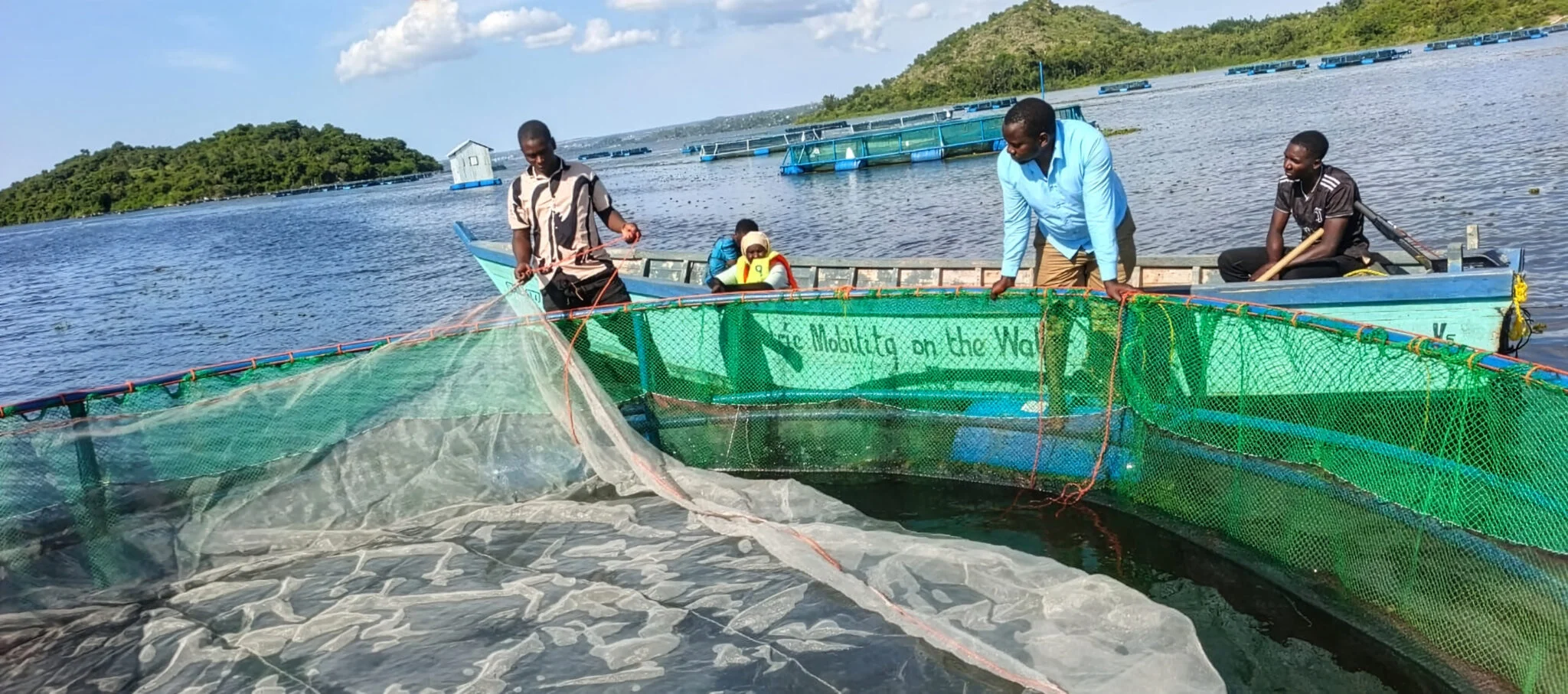 Electric service boat operating at the Luchelele fish cages on Lake Victoria